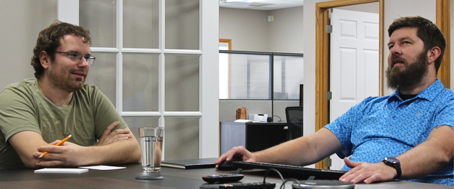 a bearded engineer and a man left-handed discussing something difficult